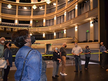 Tour member looks up at the complex catwalks above opera stage