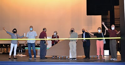 Members stand on opera stage