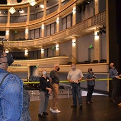 Tour member looks up at the complex catwalks above opera stage